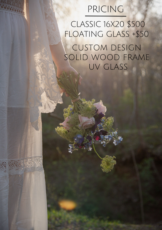 This image displays pricing for a pressed flower bouquet display. The offerings include:
Classic 16x20: $500
Floating Glass: +$50
Custom Design with Solid Wood Frame and UV Glass
The photo features a bride holding a bouquet while wearing a lacey white dress, with soft sunlight in the background.